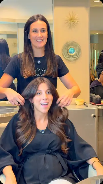 Clienta embarazada sonriendo tras su cambio de look en morena con ondas